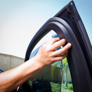 Man at Jax Auto Spa installing window tinting on car - auto detailing in Jax Florida