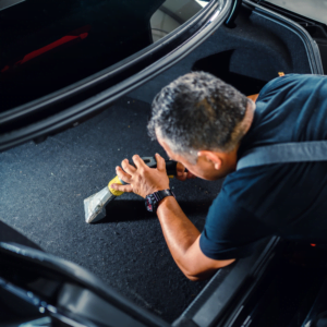 Professional worker at Jax Auto Spa cleaning car interior